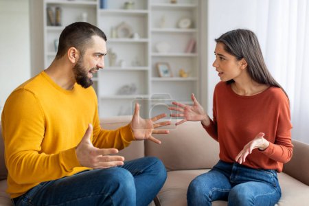 Un homme et une femme assis sur un canapé engagés dans une discussion animée, peut-être révélatrice d'une dispute familiale ou de problèmes relationnels
