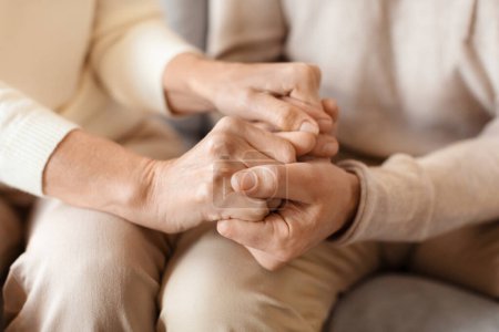 Eine intime Aufnahme zweier Menschen, die sich an den Händen halten, symbolisiert Unterstützung, Trost und eine starke Bindung zwischen ihnen