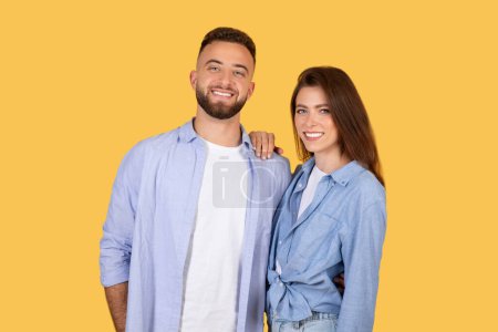 Un homme et une femme souriants debout de près, tous deux habillés en denim décontracté, affichant un lien étroit et des vibrations positives