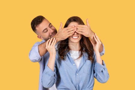 Ein verspieltes Bild eines Mannes und einer Frau in einem Ratespiel, bei dem die Hände über den Augen des anderen Vertrauen und Verspieltheit ausdrücken