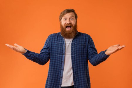 Photo for Wow Offer. Portrait Of Joyful Bearded Redhaired Guy Reacting To Great News, Spreading Hands In Excitement While Shouting Joyfully Over Orange Studio Backdrop. Joy and Happiness Concept - Royalty Free Image