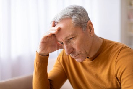 Indicative of a headache or serious concern, the elderly male appears troubled and in need of care or comfort