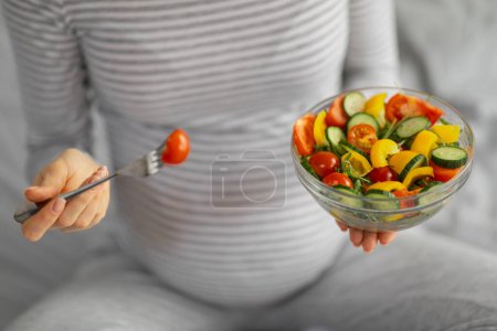 Photo for Handing over of a vibrant salad bowl, showcasing the importance of healthy eating choices for pregnant women - Royalty Free Image