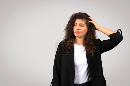 Una mujer de negocios con una expresión confusa, mano sobre cabeza, lo que significa malentendido