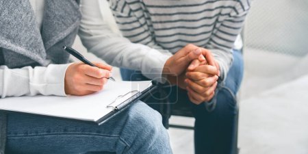 Photo for You Can Trust Me. Unrecognizable Female Psychologist Comforting Depressed Woman Patient, Making Support Gesture And Taking Notes To Clipboard - Royalty Free Image