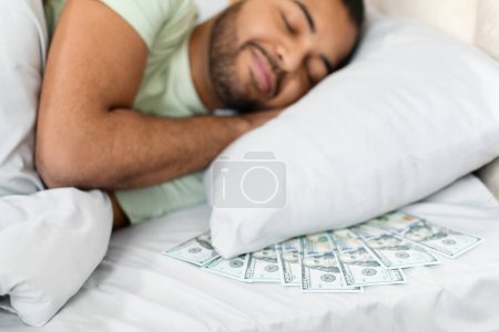 Billetes de cien dólares crujientes se extienden en una cama, lo que simboliza conceptos financieros o inesperada ganancia inesperada. El malo se acuesta con su dinero