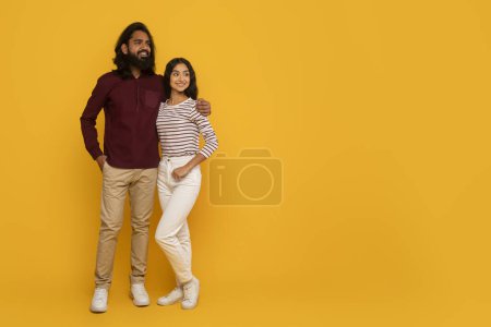 Téléchargez les photos : Un homme et une femme se tiennent dos à dos avec les bras croisés, dégageant une ambiance détendue sur un fond jaune - en image libre de droit