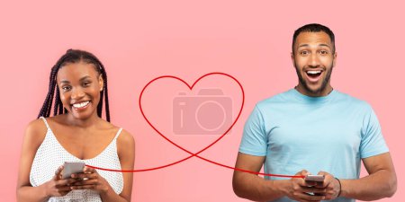 Photo for A delighted woman and an enthusiastic man in a blue t-shirt are holding smartphones, connected by a red heart line against a pink background, representing virtual communication with joy - Royalty Free Image