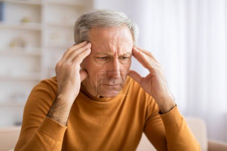 Ein älterer Mann ist gefangen in einem Moment der Kontemplation oder Entscheidungsfindung, die Hände vor dem Gesicht, verloren in Gedanken