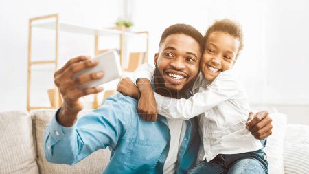 Foto de Padre joven con hija tomando selfie en el teléfono inteligente en casa - Imagen libre de derechos