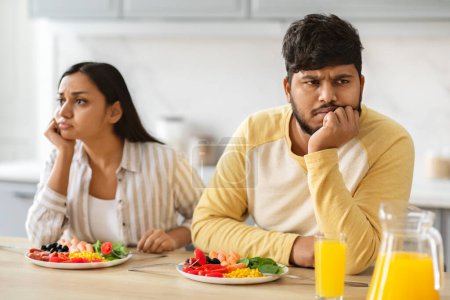Foto de Frustrados millennial indio cónyuges marido y mujer tienen lucha durante el desayuno en la cocina en casa. Pareja oriental infeliz que experimenta dificultades en el matrimonio, relaciones - Imagen libre de derechos