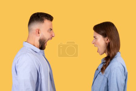 Photo for Two people man and woman yelling at each other, standing face to face on a yellow background, suggesting disconnect or disagreement - Royalty Free Image