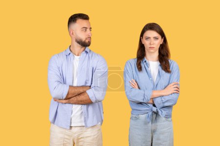 Photo for Man and woman standing with arms crossed, showing a standoffish or confrontational attitude - Royalty Free Image