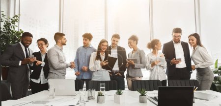 Photo for An enthusiastic team of professionals enjoying a light-hearted moment together in an office lobby, showcasing a positive work culture - Royalty Free Image