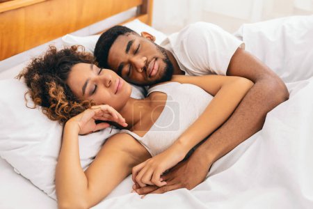 Téléchargez les photos : Un aperçu intime de couples afro-américains partageant une tendre étreinte sur leur lit, illustrant l'essence de l'amour et du partenariat - en image libre de droit