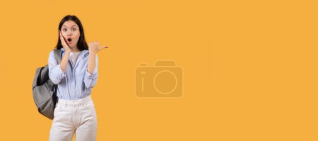 Téléchargez les photos : Femme surprise avec sac à dos gesticule avec les yeux larges et la bouche ouverte comme étonnée, sur un fond orange - en image libre de droit