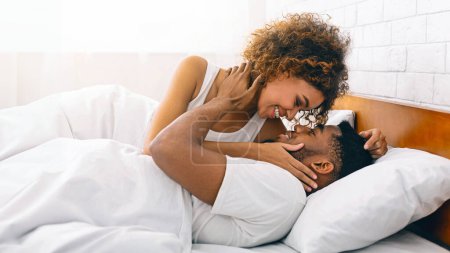 Téléchargez les photos : Bonne matinée ensemble. afro-américaine fille baisers son chéri dans lit, gros plan - en image libre de droit