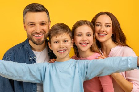Enge Umarmung der Familie mit zwei Kindern und glücklichen Eltern, Nahaufnahme von vier glücklichen Gesichtern, Selfie machen