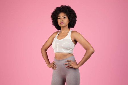 Confident African American woman with hands on hips in sportswear