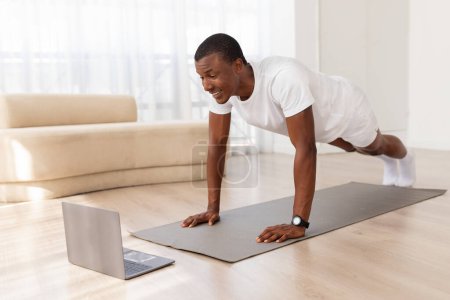 This image captures African American man holding a push-up position attentively in a tidy, spacious room