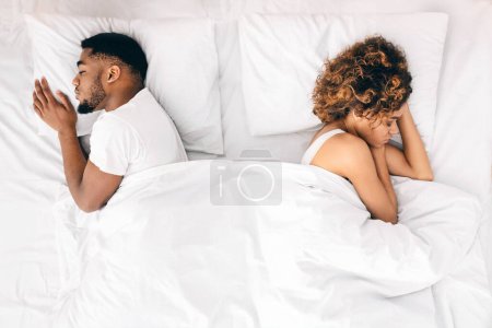 Téléchargez les photos : Problème relationnel. Couple afro-américain bouleversé dormant séparément sur leur lit, vue sur le dessus, espace libre - en image libre de droit