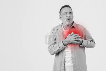 Senior man clutches his chest in pain, with a highlighted heart area indicating potential heart troubles or discomfort