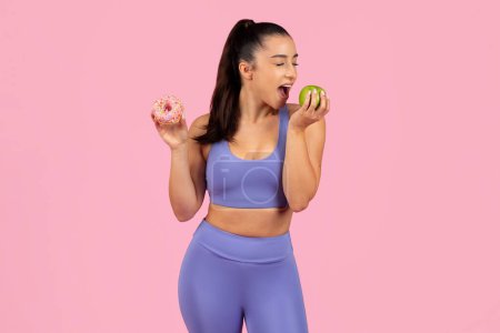 Una mujer en forma en ropa deportiva se enfrenta a la elección entre una manzana sana y una dona poco saludable