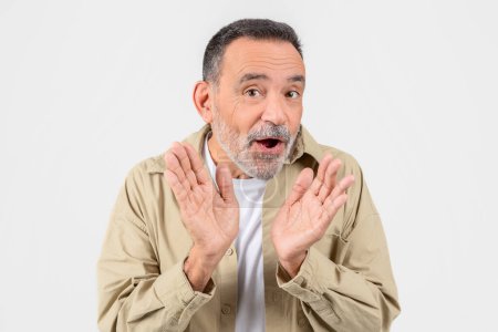 Elderly man with a surprised expression on his face, hands raised and gesturing, isolated on a white background