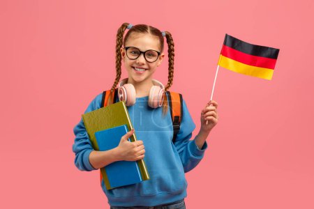 Ein junges Mädchen mit Zöpfen, Brille und Kopfhörern hält Schulbücher und eine deutsche Fahne in der Hand, die für das Erlernen der Sprache steht.