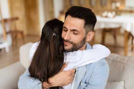 Daughter shows deep affection with a heartfelt hug to her father in a tender, emotional family moment
