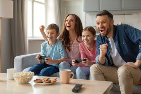 Père de famille excité mère et les enfants profitant d'une séance de jeu sur leur canapé avec joie et rire ensemble