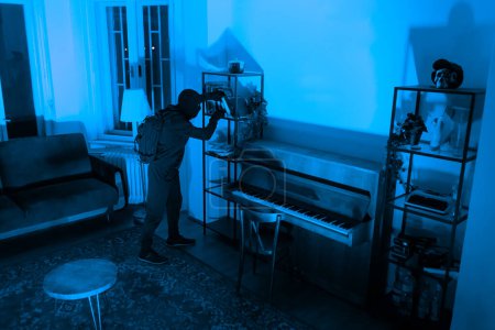 Das Bild zeigt einen mysteriösen Einbrecher in Aktion in einem Raum mit einem Vintage-Piano und subtilem Vintage-Dekor