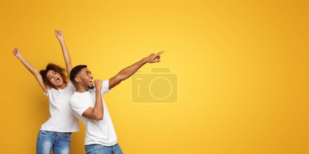 Téléchargez les photos : Couple afro-américain devenir fou, danser et chanter sur fond de studio orange - en image libre de droit