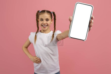 Photo for Girl with braids confidently showing a blank smartphone screen towards the camera on pink background, nice app - Royalty Free Image