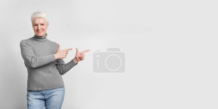 Téléchargez les photos : Une femme européenne âgée souriante donne un double pouce, un symbole d'approbation et de positivité dans le contexte de s3niorlife - en image libre de droit