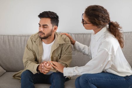 Photo for Therapist consoling middle eastern young man patient during a therapy session showcasing care and support - Royalty Free Image