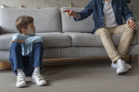 Foto de La imagen presenta a un niño siendo disciplinado por un padre, describiendo conceptos de paternidad, autoridad y comportamiento infantil. - Imagen libre de derechos