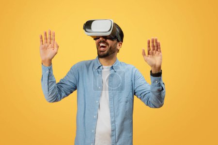 Indian man experiences virtual reality technology against a bright yellow backdrop, emphasizing the contrast