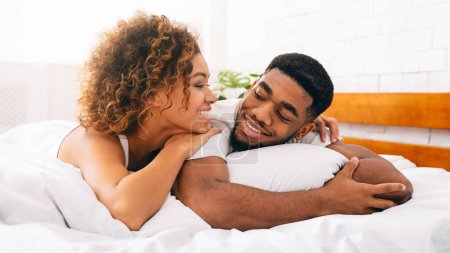 Foto de Amando pareja negra relajándose en la cama en casa, disfrutando de dulces buenos días juntos - Imagen libre de derechos