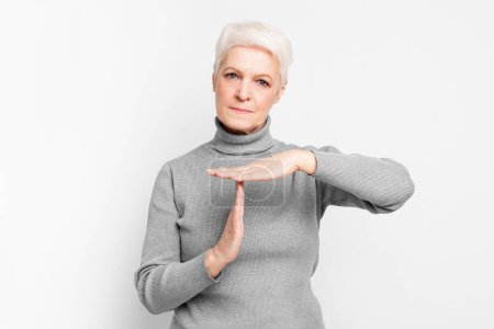 Photo for The senior, elderly European woman performs a timeout gesture, illustrating a moment of pause or respite in the context of s3niorlife - Royalty Free Image