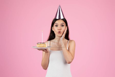 Téléchargez les photos : Une dame semble surprise tout en tenant un gâteau d'anniversaire sur une assiette, mettant en valeur une scène d'été européenne tranquille, parfaite pour la génération z, isolée - en image libre de droit