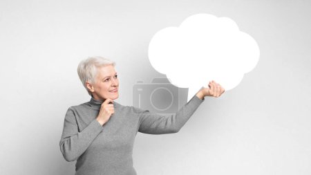 Téléchargez les photos : Une femme âgée européenne pointe vers une bulle d'expression transparente, parfaite pour transmettre des idées par s3niorlife - en image libre de droit