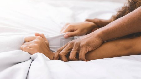 Foto de Pasión en la cama. Afro-americano pareja manos tirando blanco sábanas en éxtasis, primer plano - Imagen libre de derechos