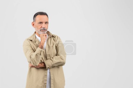 Téléchargez les photos : An elderly man with grey hair, beard, and a contemplative expression, isolated on a white background, radiates a thoughtful mood, copy space - en image libre de droit