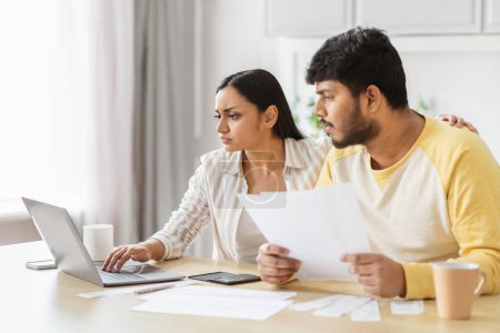 A focused indian couple delves into financial planning, portraying the responsibility and partnership of millennial spouses managing a household together