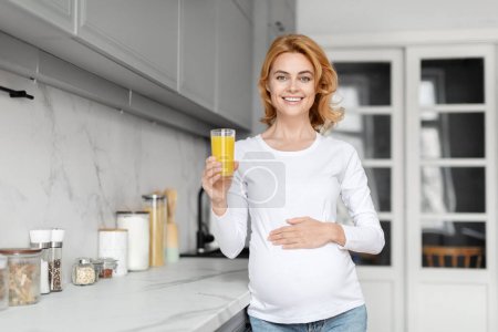 Eine strahlende schwangere Europäerin genießt Orangensaft in einer stilvollen Küche und zeigt die Bedeutung von Obst in der pränatalen Ernährung