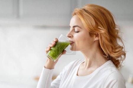 Highlighting nutrition, a close-up of a european pregnant lady enjoying a healthy beverage in a home kitchen setting