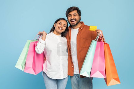 Foto de Emocionado joven pareja india con coloridas bolsas de compras, expresando el placer de una exitosa juerga de compras - Imagen libre de derechos