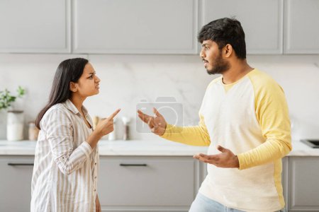 Indische Männer und Frauen liefern sich in einer modernen Küche einen hitzigen Streit, der Beziehungskonflikte und häusliches Leben illustriert