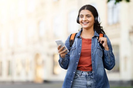 Téléchargez les photos : Une étudiante indienne s'engage avec son smartphone, dépeignant l'intersection de la technologie et de l'éducation pour un zoomeur sur un campus - en image libre de droit